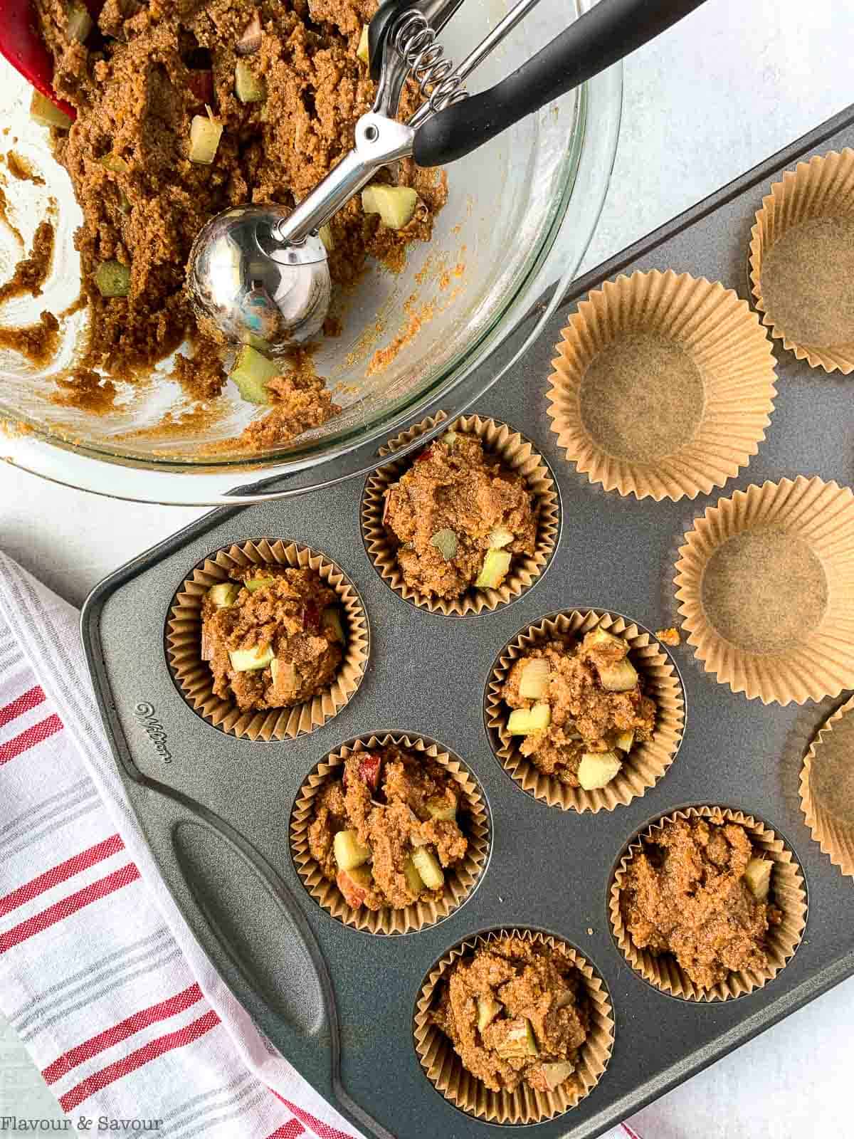 filling muffin cups with rhubarb muffin batter