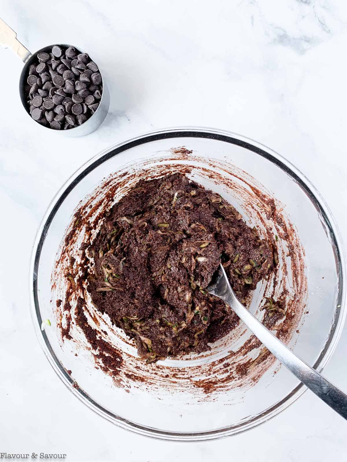 Combining wet ingredients and dry ingredients for double chocolate zucchini bread.