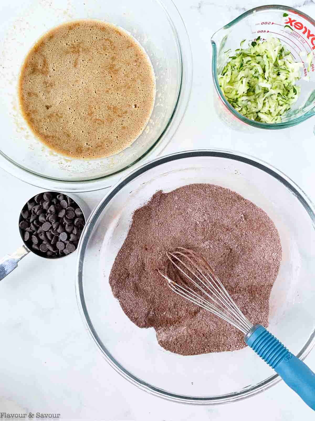 Whisking wet ingredients and dry ingredients in two bowls.