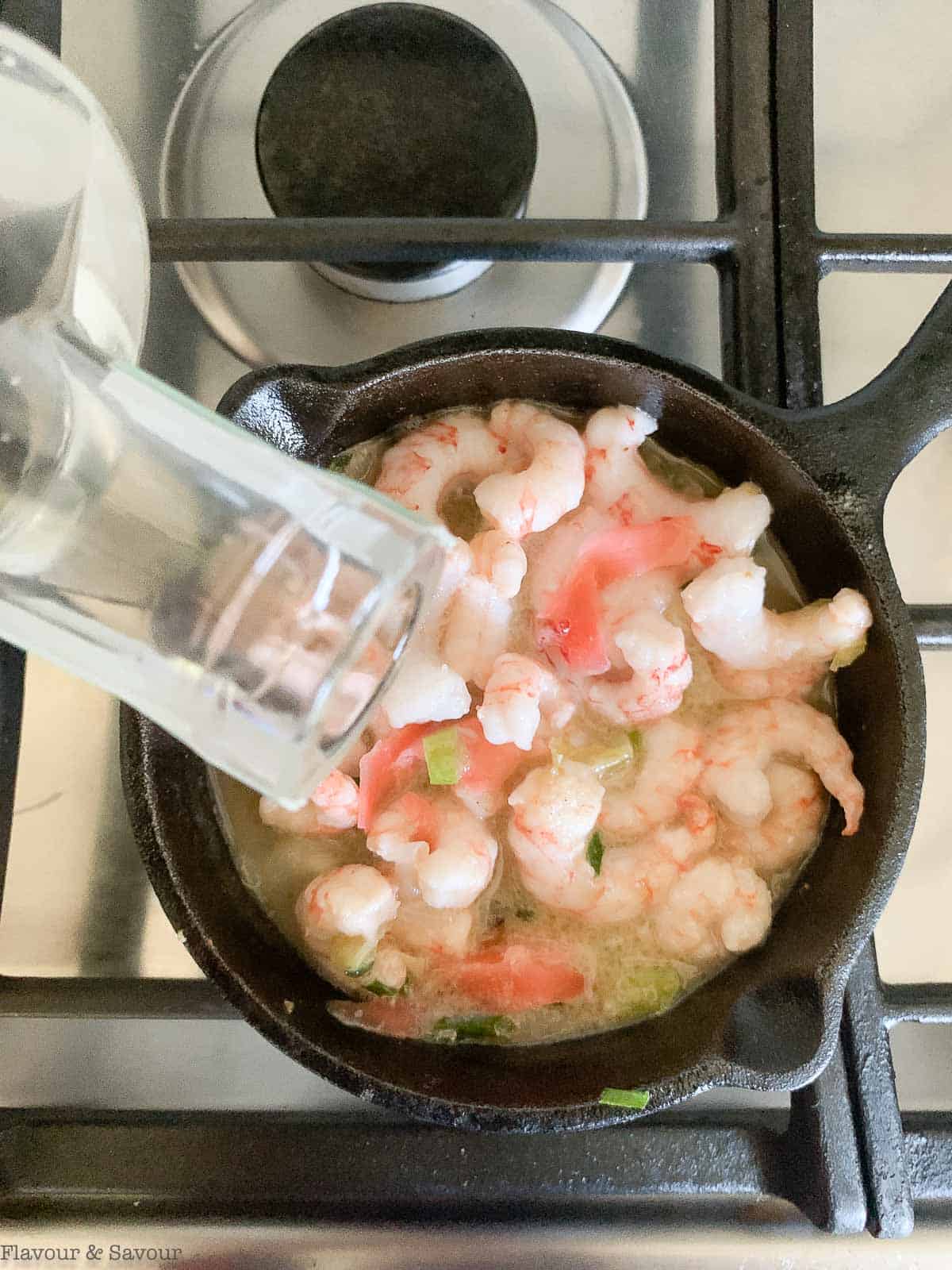 pour gin into skillet with shrimp