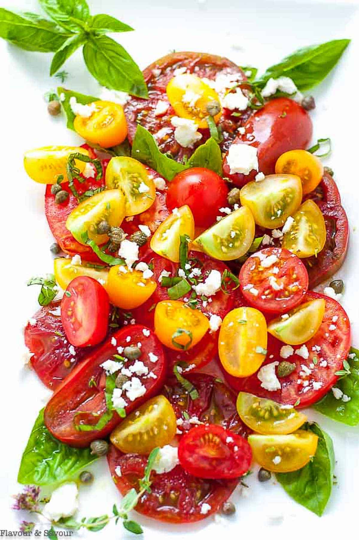 overhead view of an heirloom tomato salad with feta cheese and basil