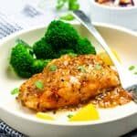 Honey Mustard Glazed Salmon made with grainy mustard on a plate with broccoli florets.