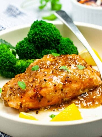 Honey Mustard Glazed Salmon made with grainy mustard on a plate with broccoli florets.