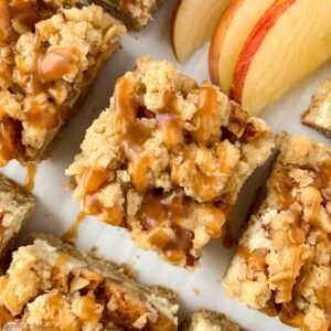 Gluten-free Apple Cheesecake Bars with Caramel Sauce close up view of one bar