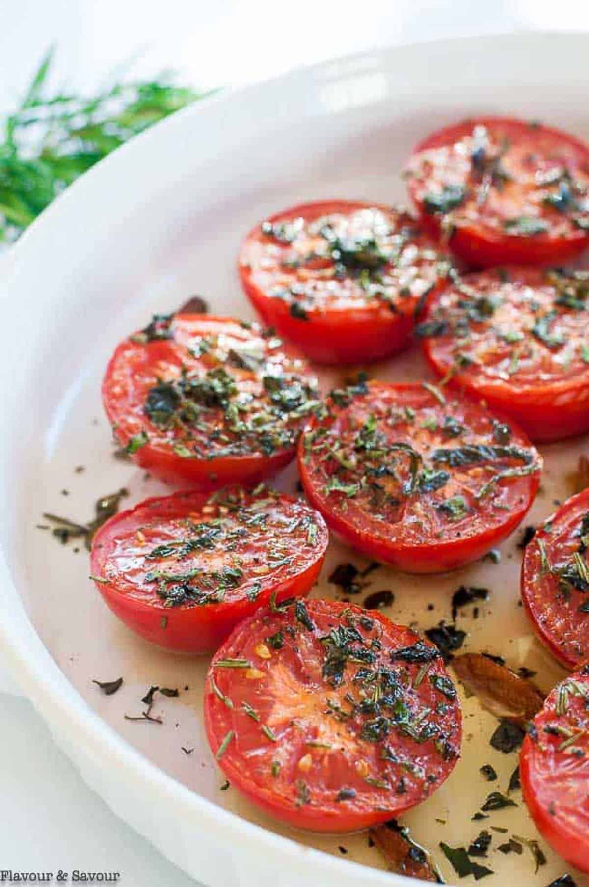 a round baking dish with tomato halves, broiled with garlic and herbs