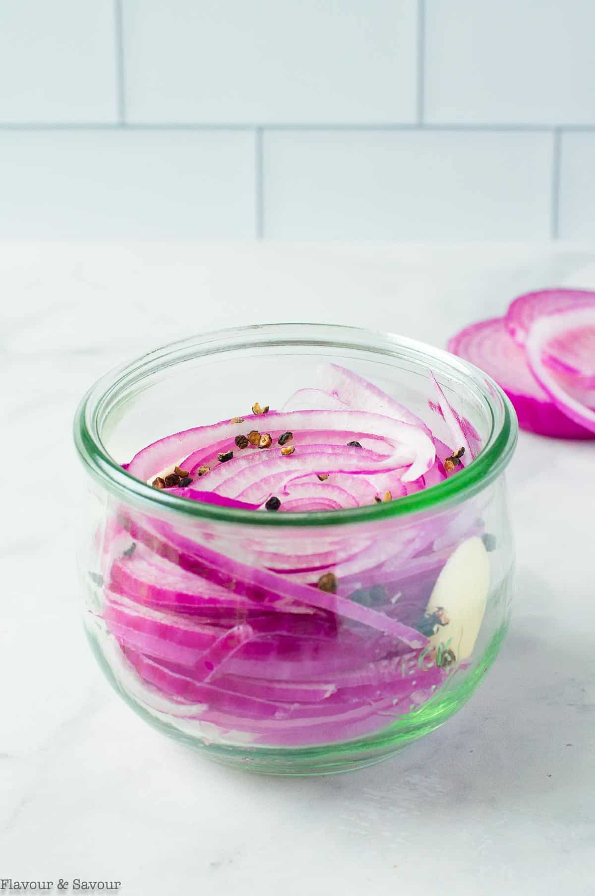 A jar filled with red onion slices.