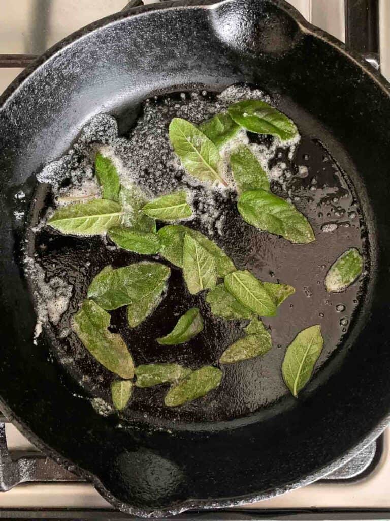 toasting sage leaves in a skillet with butter
