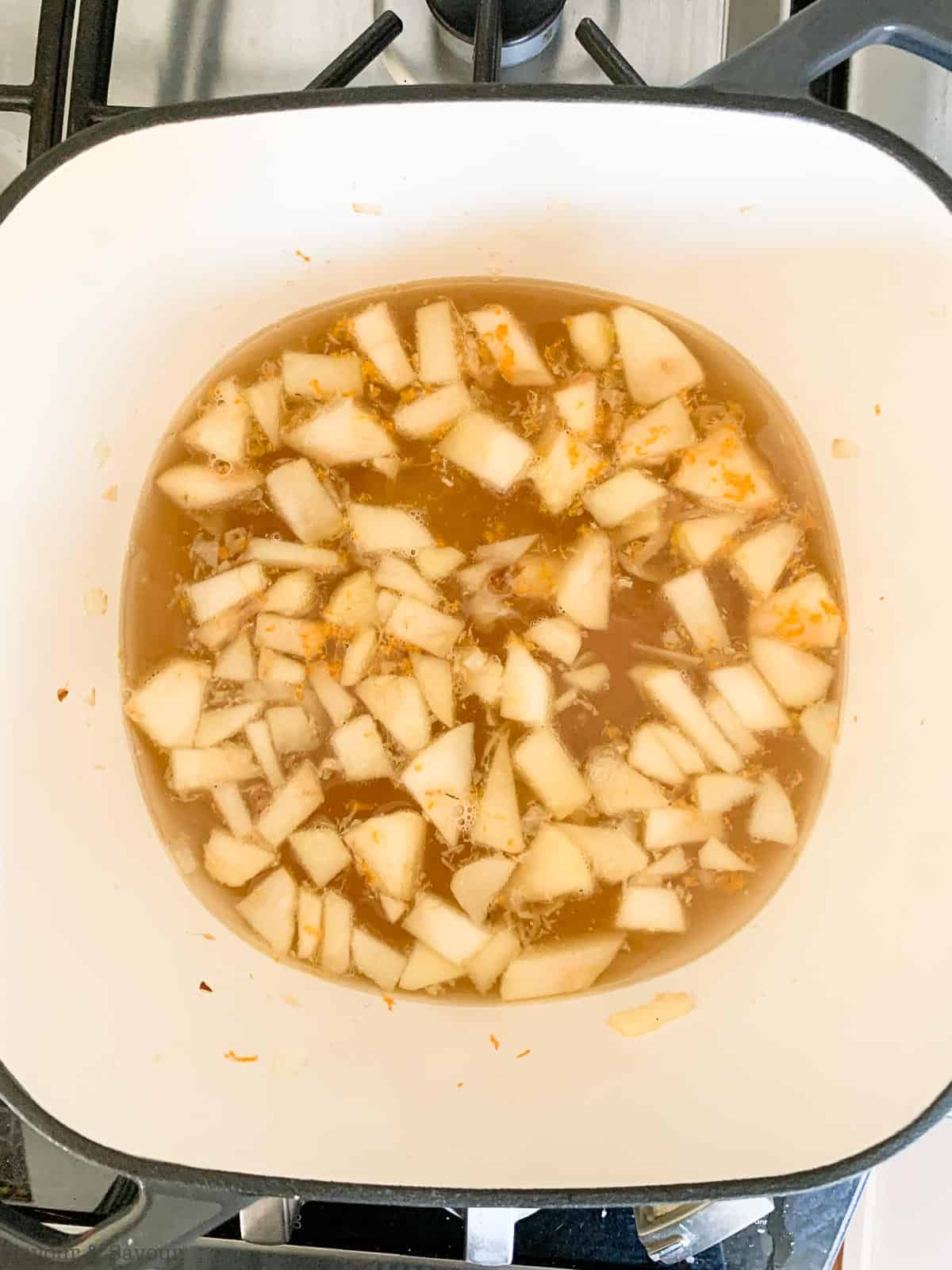 Adding broth and zest to carrot ginger soup.