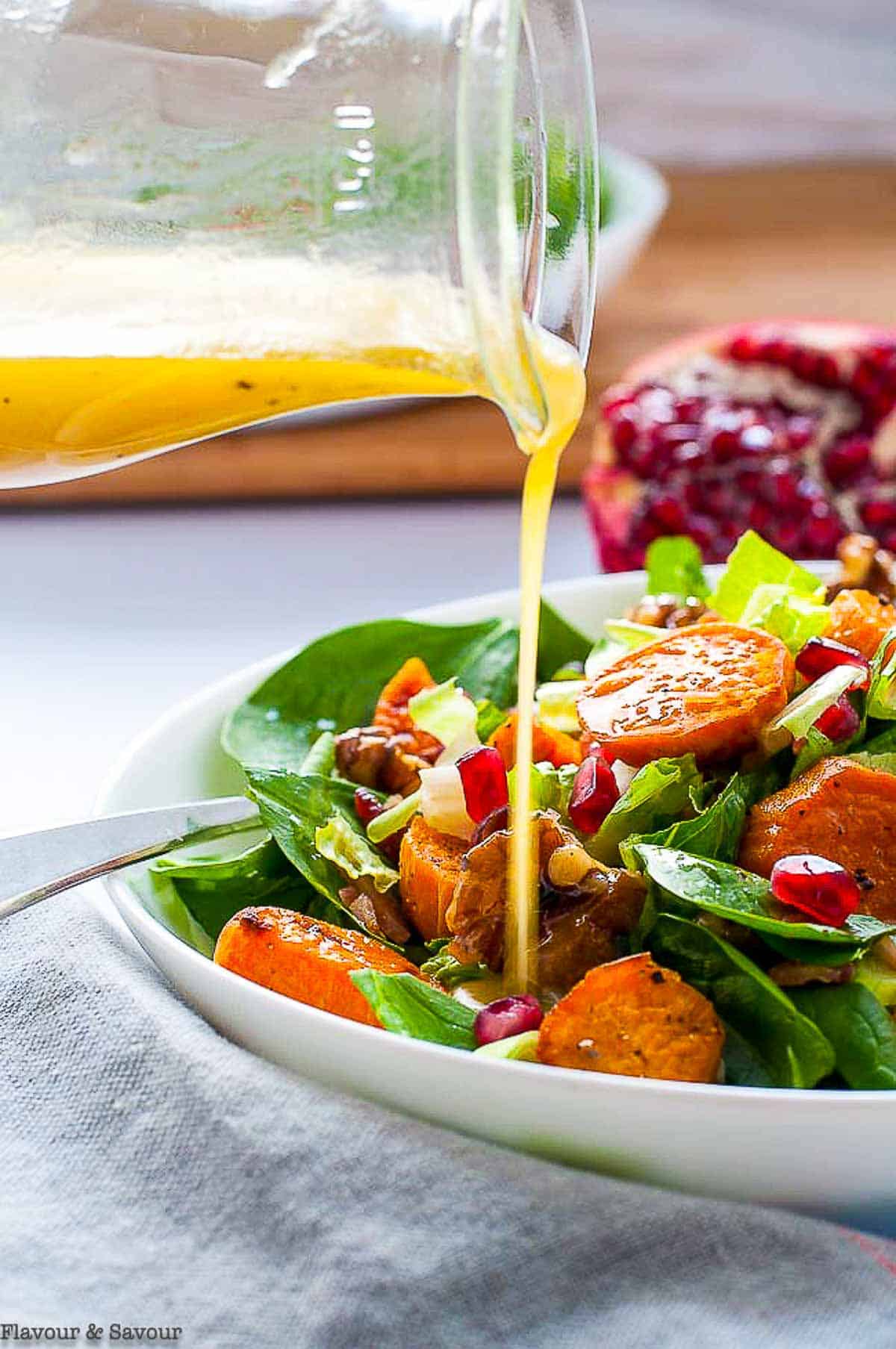 pouring dressing on sweet potato spinach salad