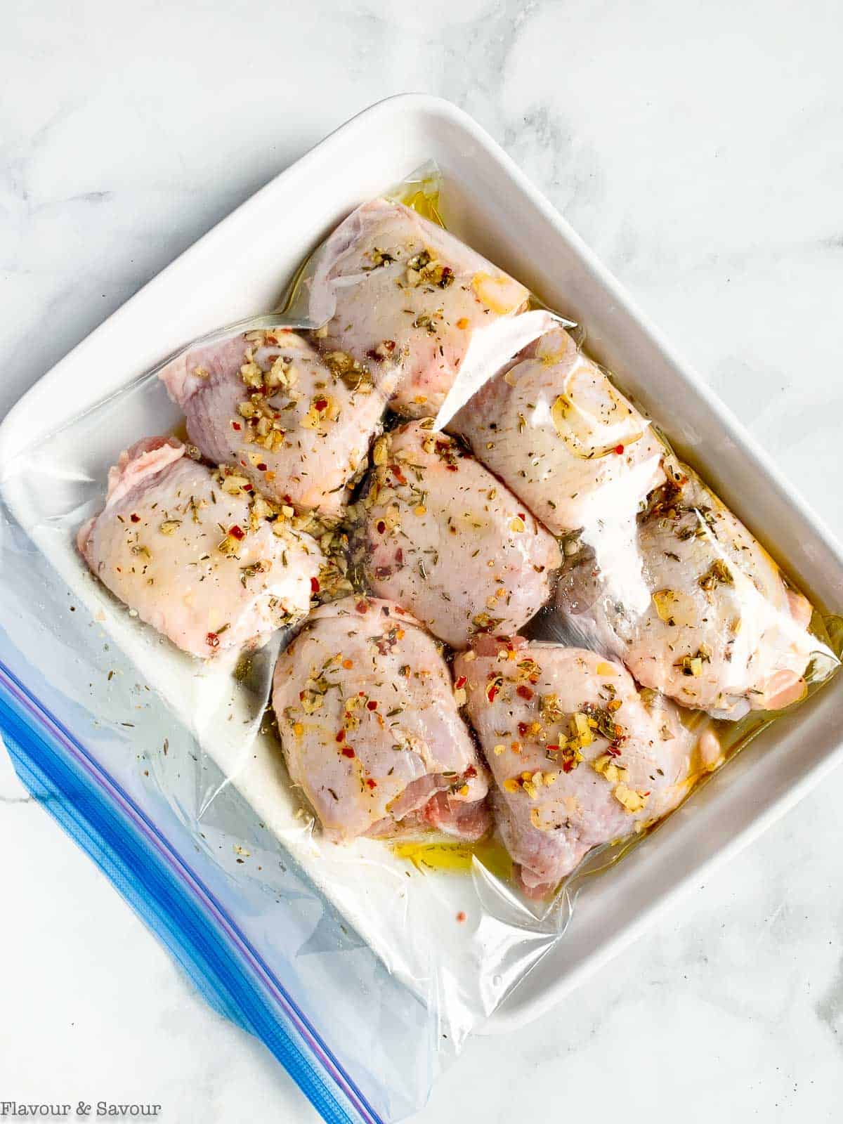Chicken thighs with marinade in a resealable bag.
