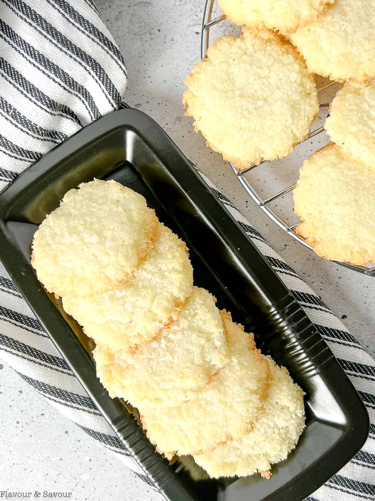 Overhead view of coconut cookies on a black plate.