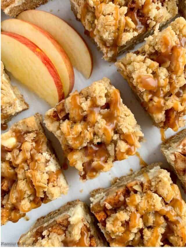 Overhead view of apple cheesecake crumble bars with fresh apple slices.