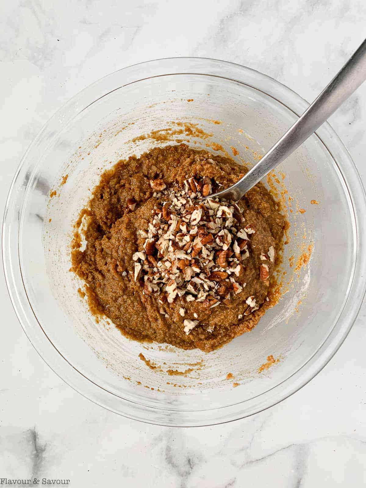 Combined wet and dry ingredients with pecans for pumpkin loaf.