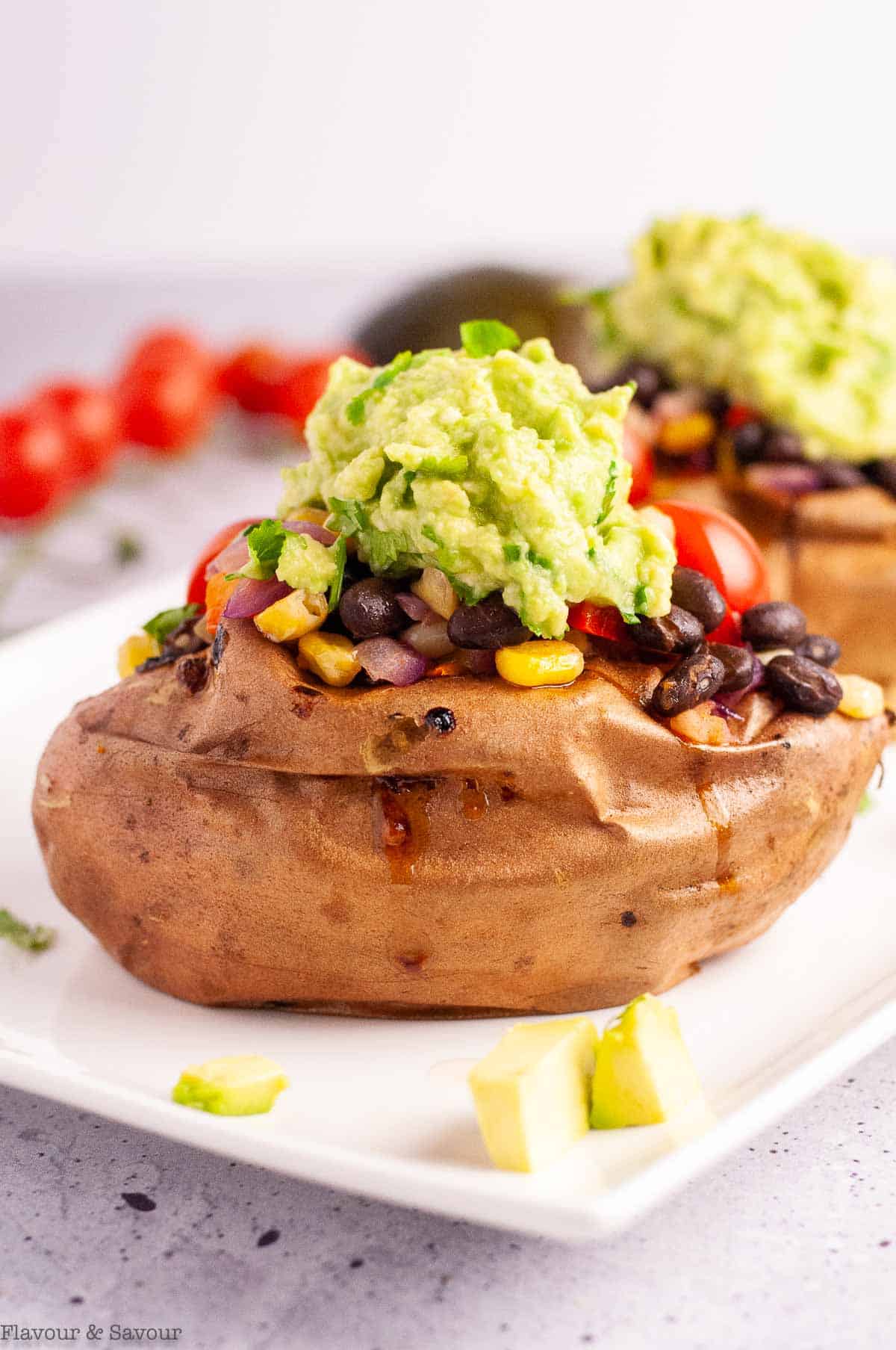 A  baked sweet potato with black beans, topped with guacamole.