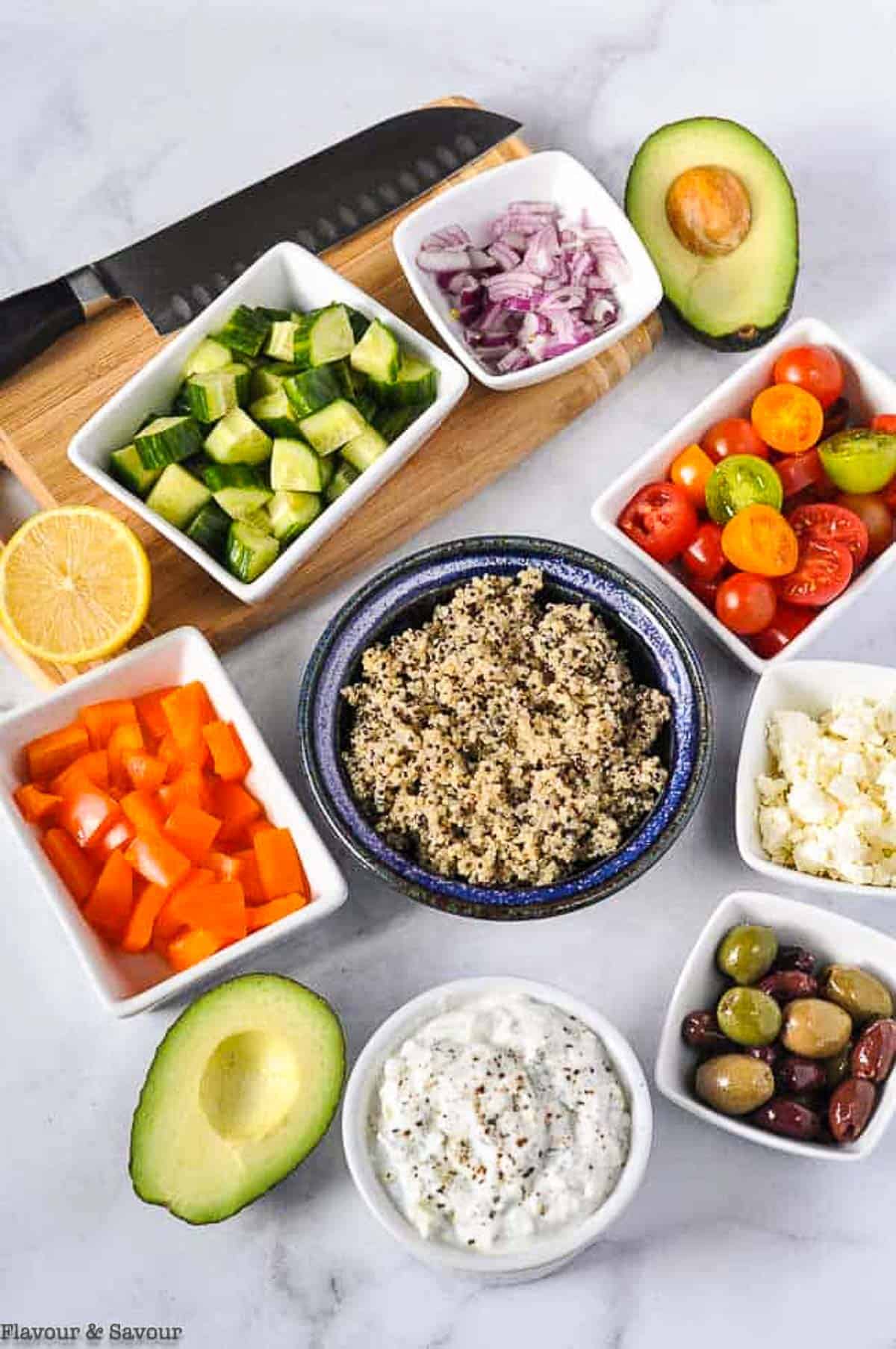 Ingredients for Mediterranean Quinoa Bowl with a knife and cutting board