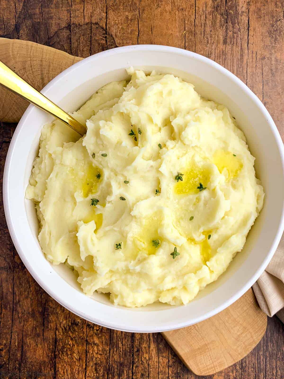 Instant Pot Garlic Mashed Potatoes in a serving bowl with a spoon.