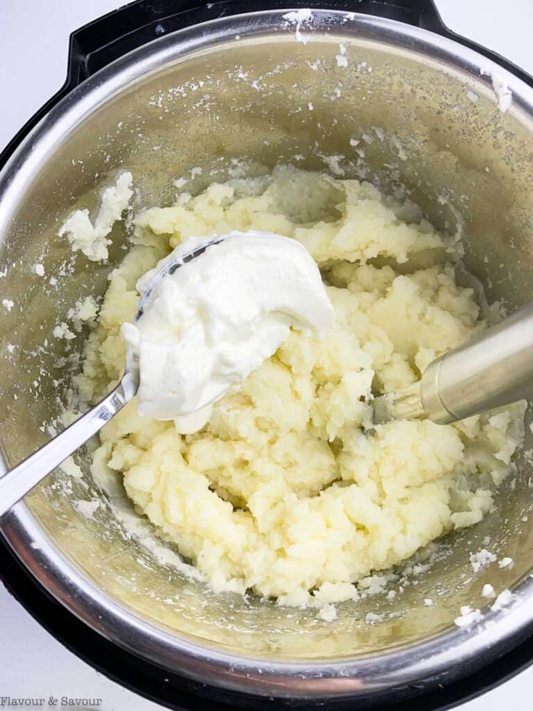 Adding sour cream to mashed potatoes.
