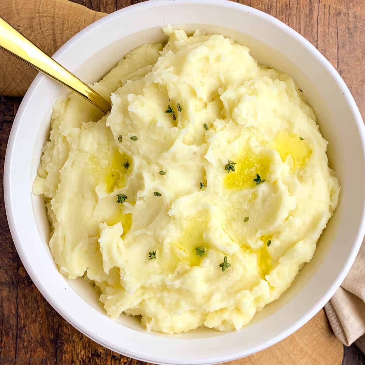 A bowl of garlic mashed potatoes with sour cream and butter.
