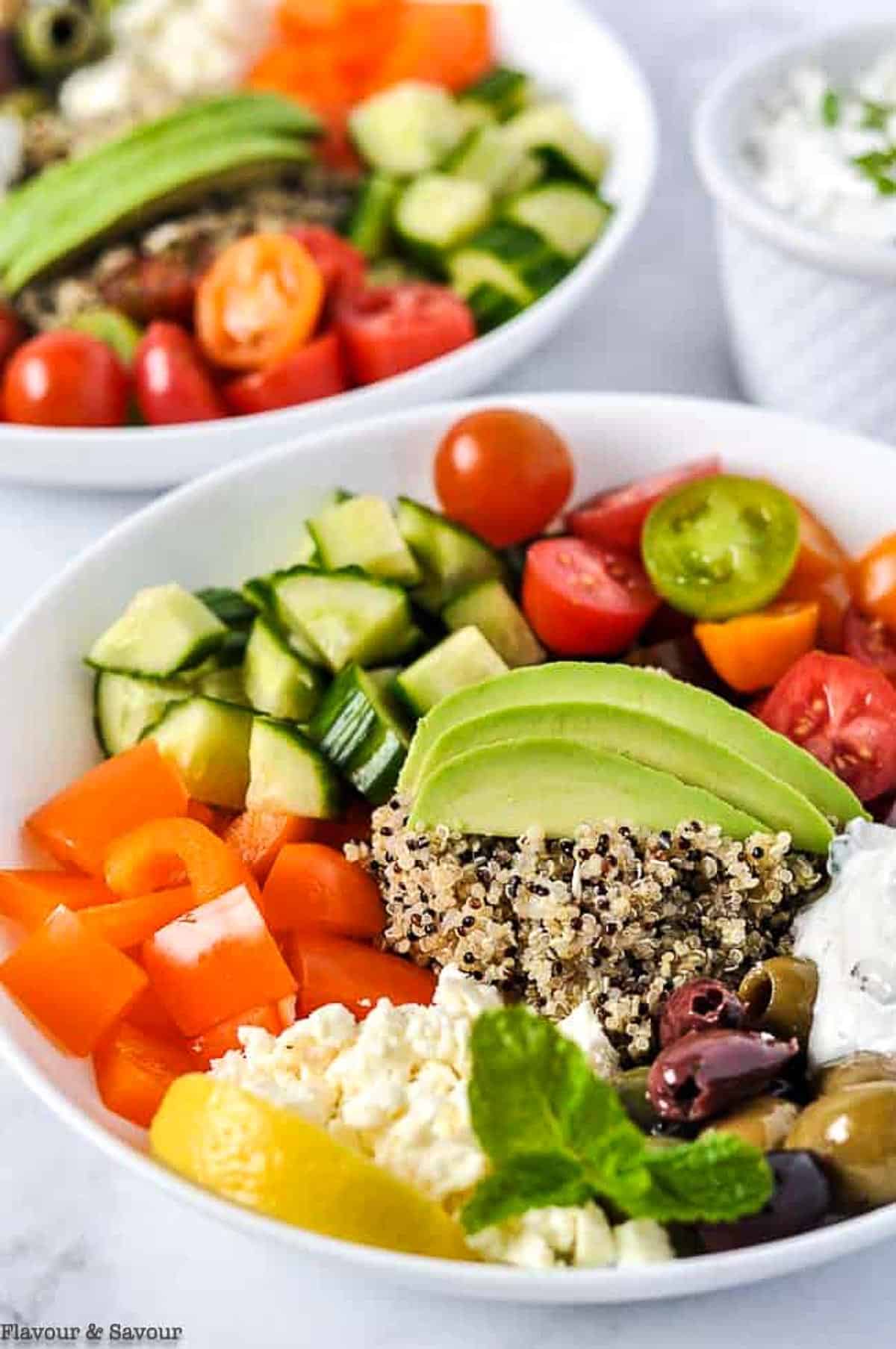 Mediterranean quinoa bowl with fresh veggies and avocado.