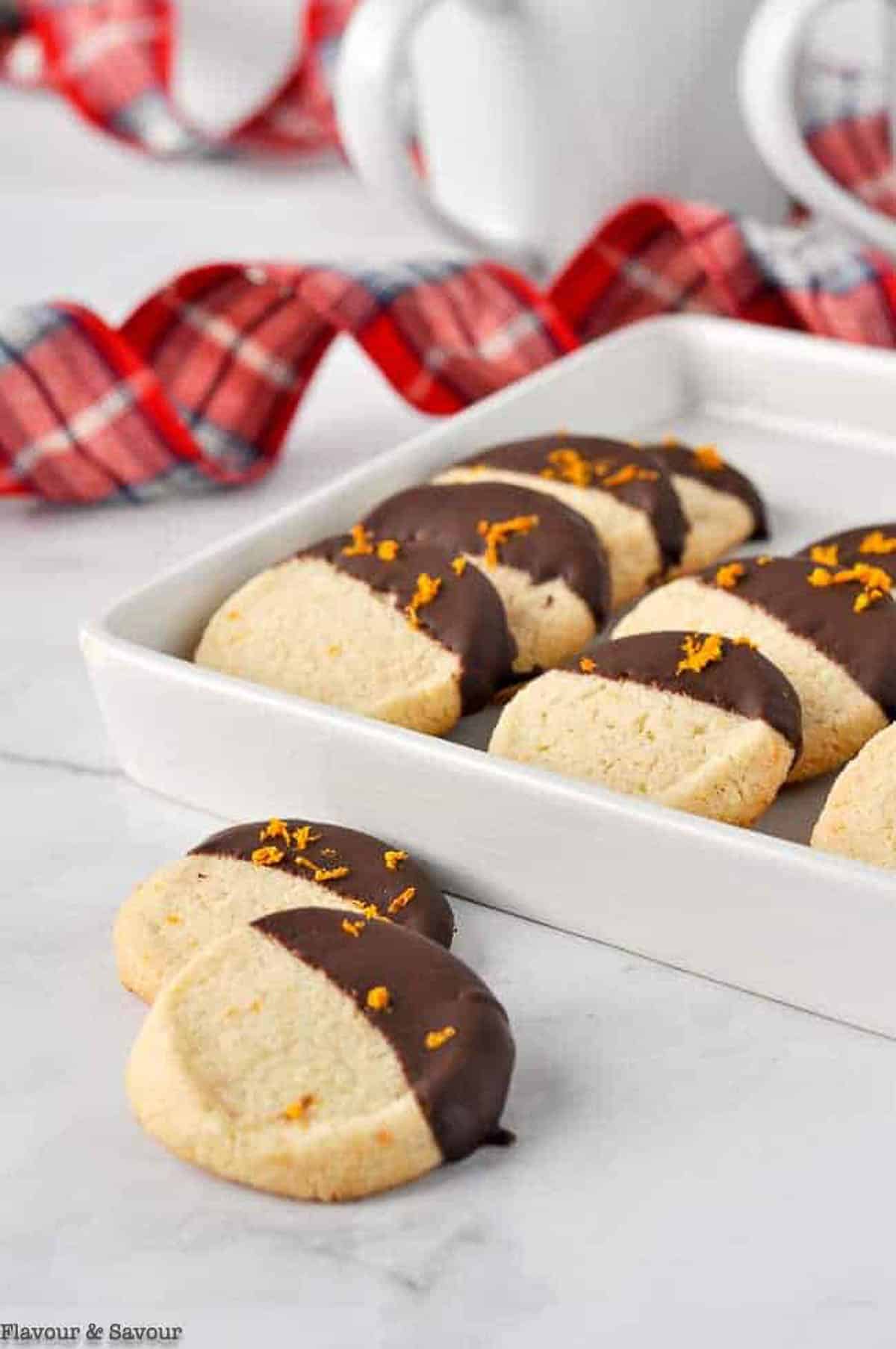 A hand choosing an almond flour cookie with chocolate dip.