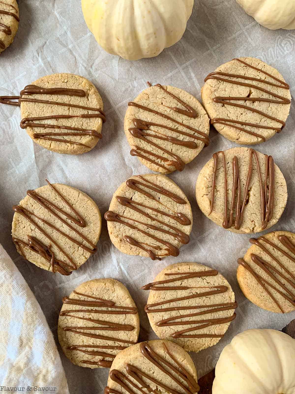 Overhead view of pumpkin spice shortbread cookies with white pumpkins.