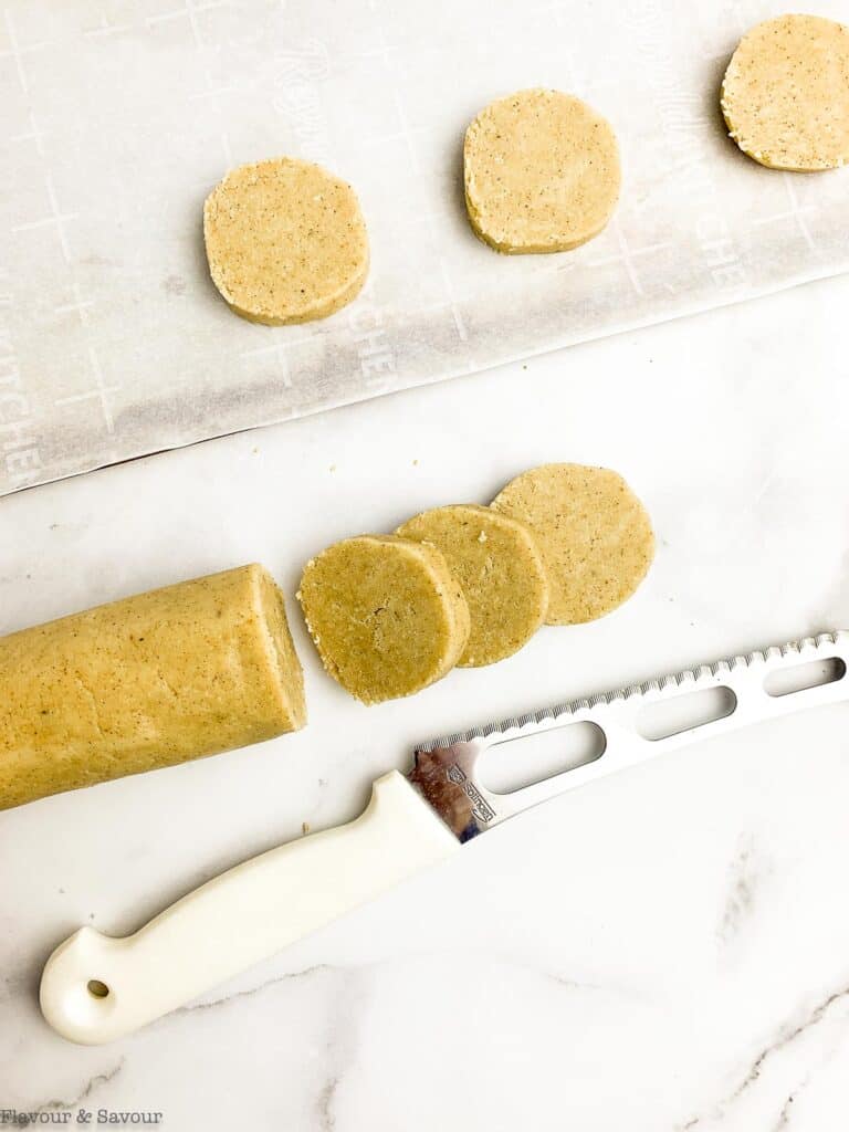 Chilled cookie dough log sliced into cookies.