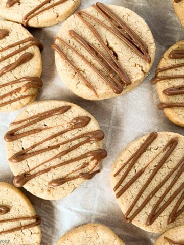 close up view of pumpkin spice almond cookies drizzled with chocolate