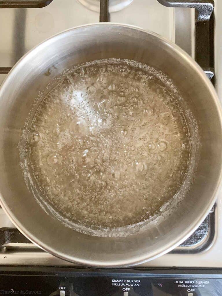 boiling sugar and water in a saucepan for caramel sauce