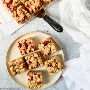 a round plate with apple pomegranate crumble bars