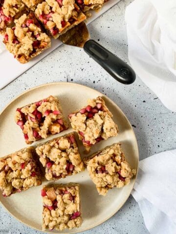 a round plate with apple pomegranate crumble bars