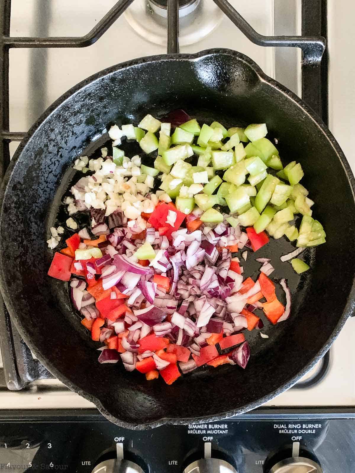 Onions peppers and tomatillos in a skillet.