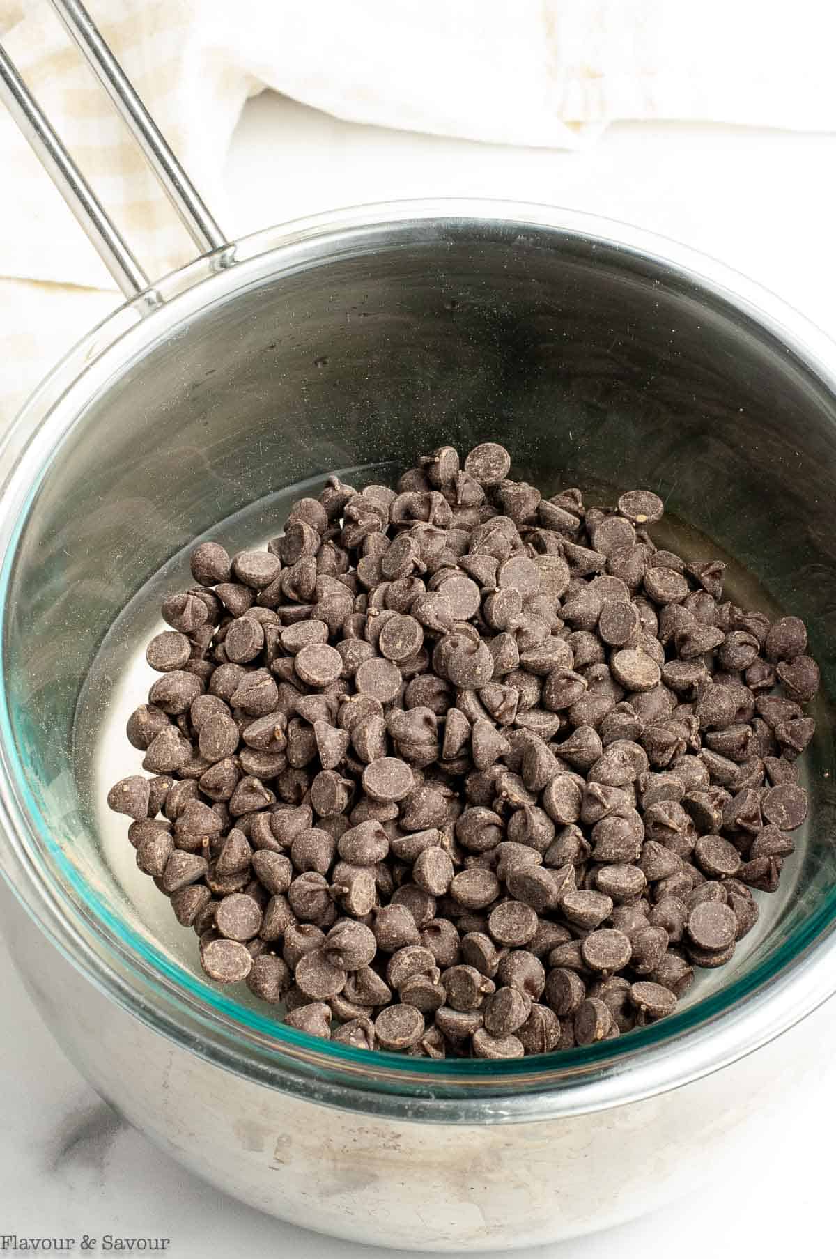 Chocolate chips in a saucepan simmering over hot water.