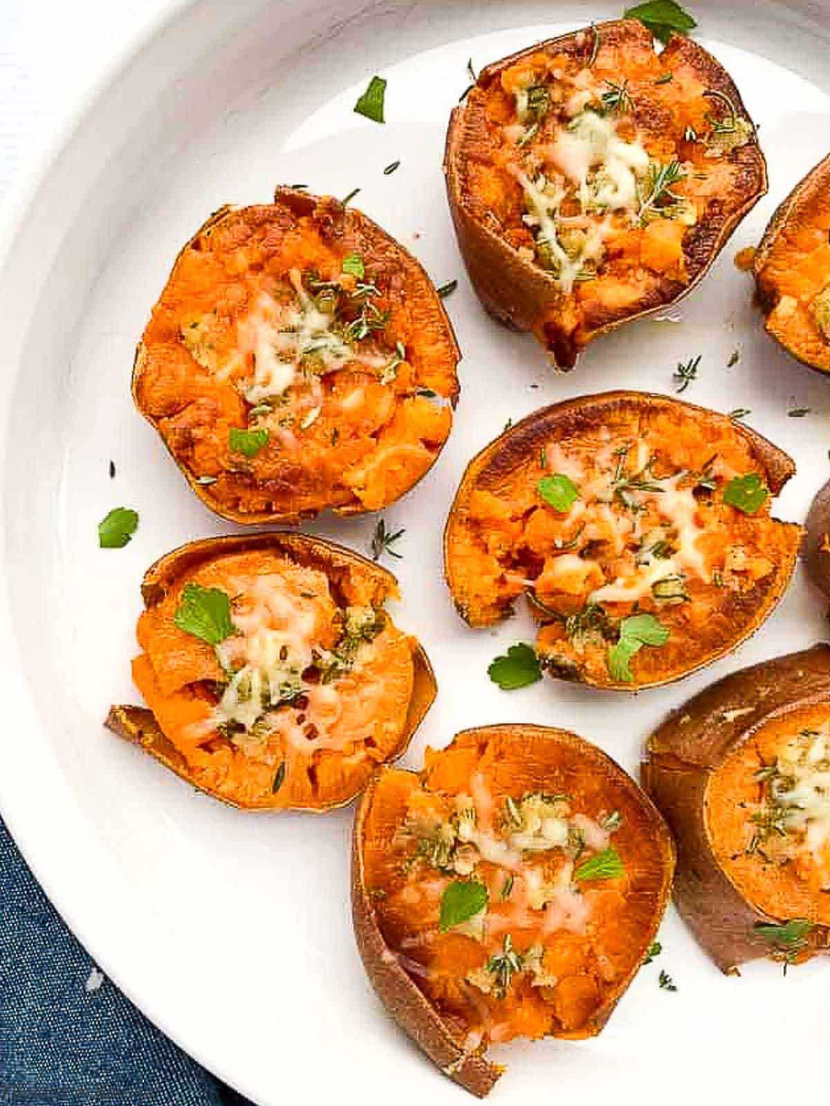 rosemary garlic smashed sweet potatoes in a white round serving dish
