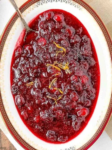 An oval bowl of spiced cranberry orange sauce.