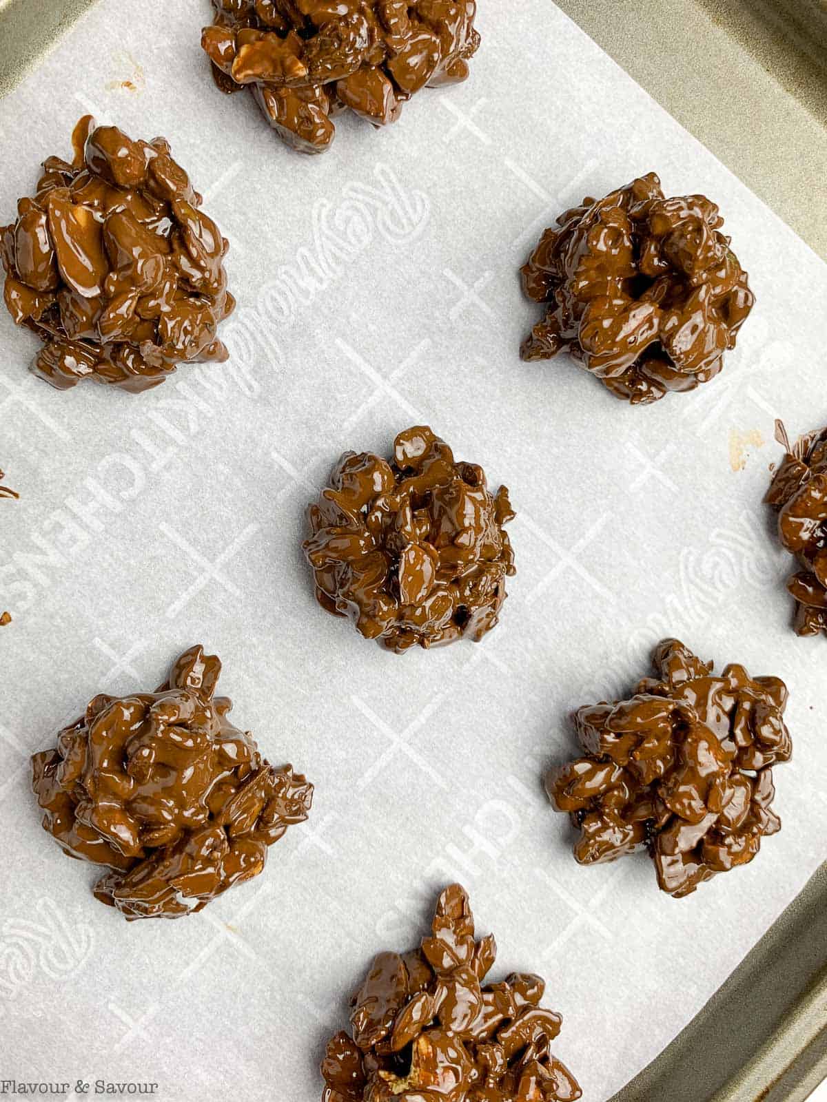 Chocolate nut clusters on a baking sheet.
