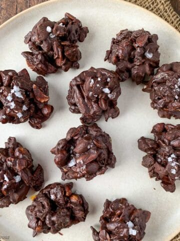 chocolate nut clusters with nuts, seeds and dried fruit on a plate