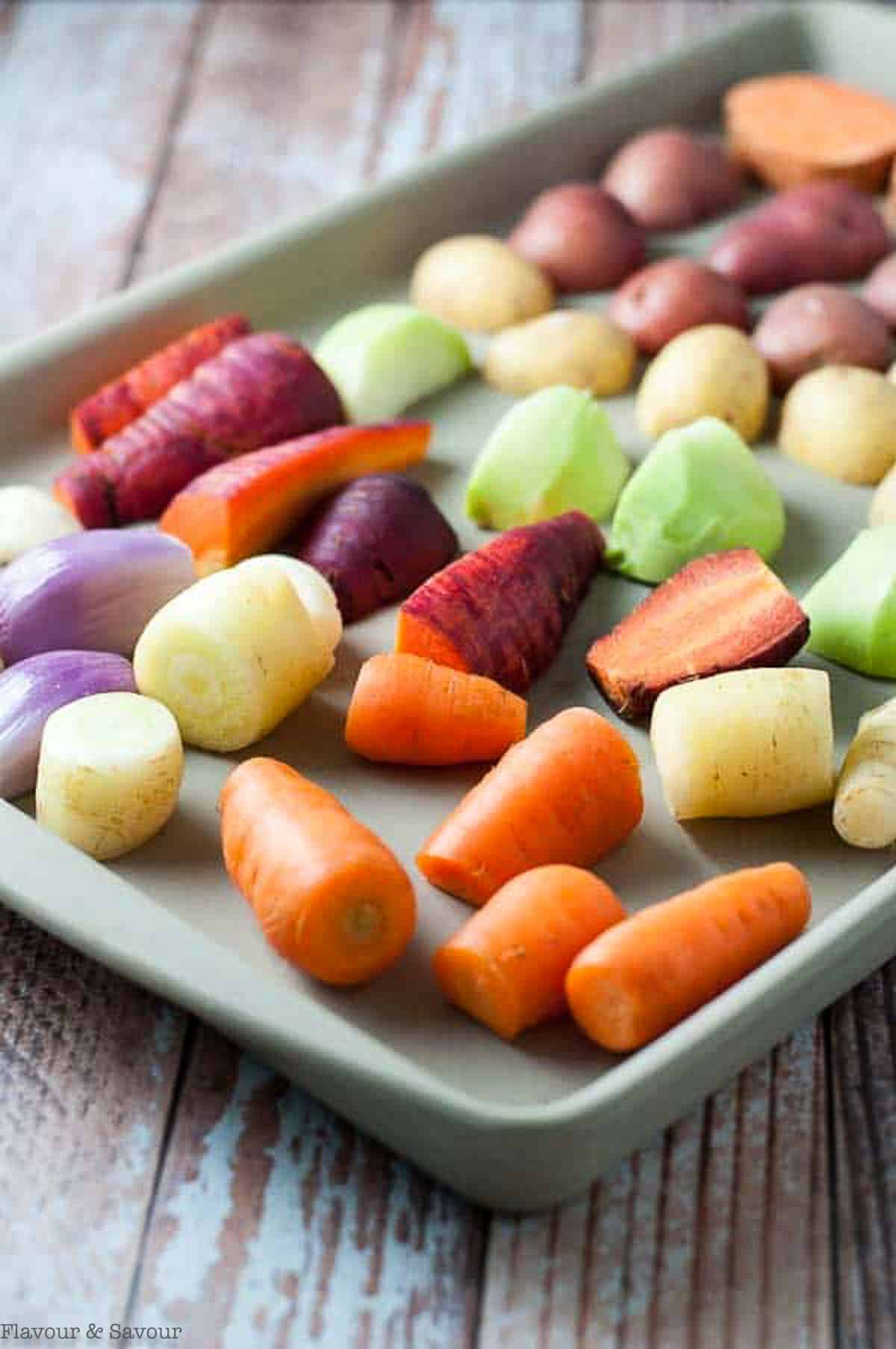 raw root vegetables on a baking pan