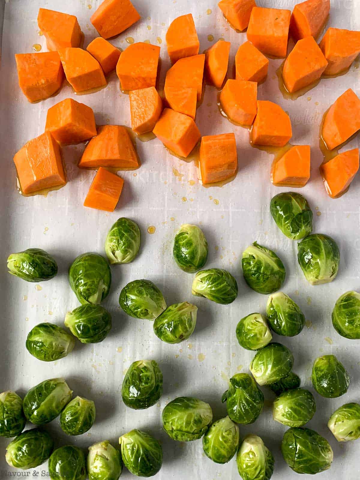 Sweet potatoes and Brussels sprouts on a sheet pan.