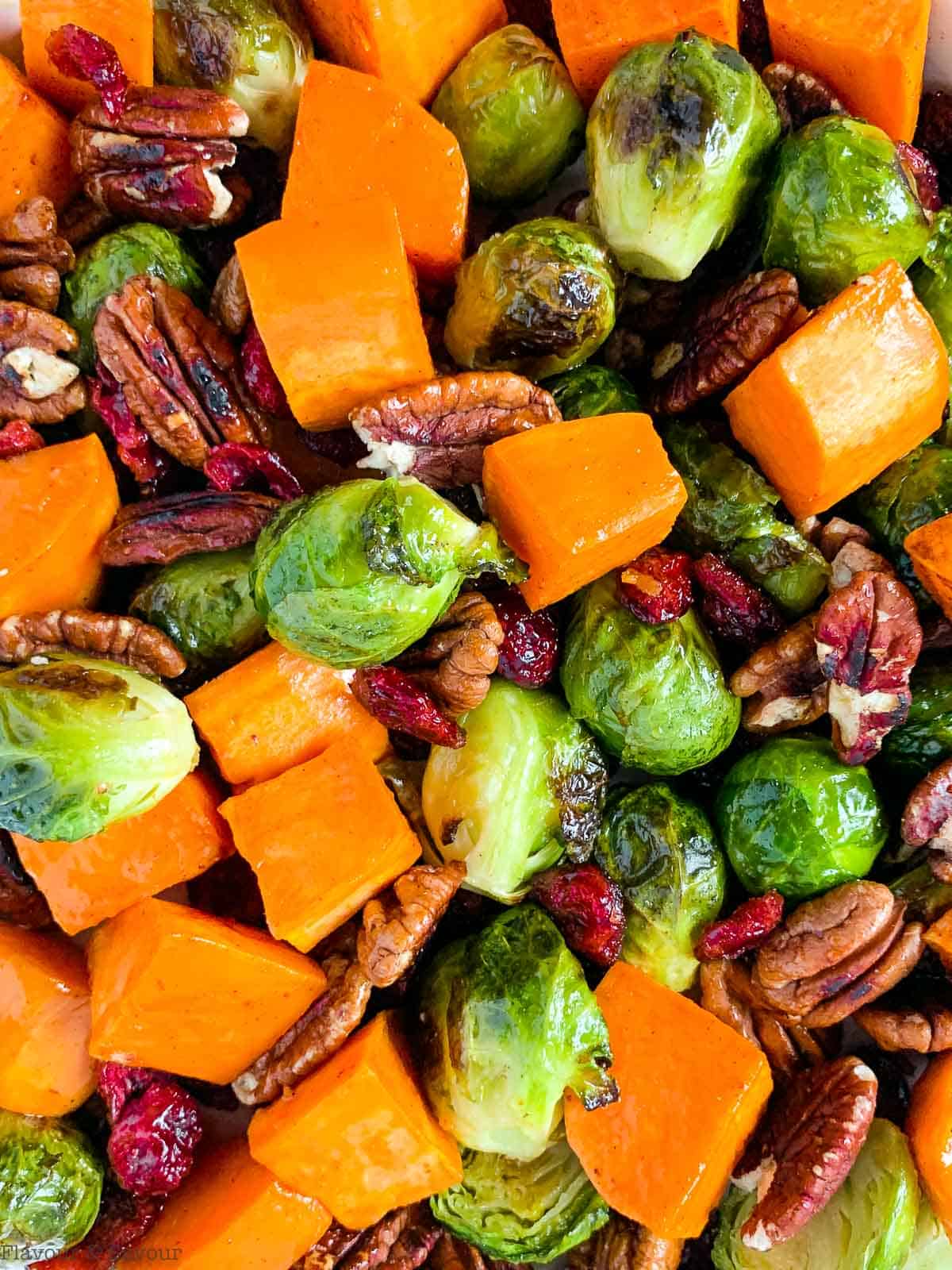A medley of roasted vegetables with Brussels sprouts and sweet potatoes.