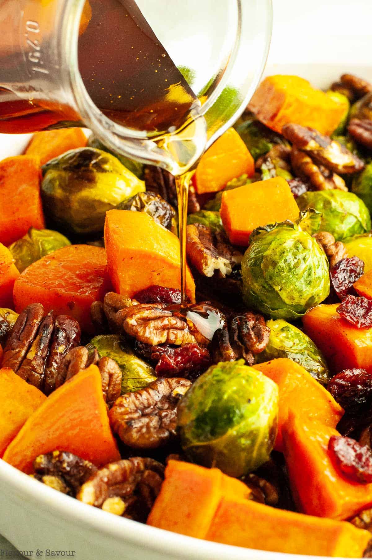Drizzling maple syrup on roasted sprouts and sweet potatoes