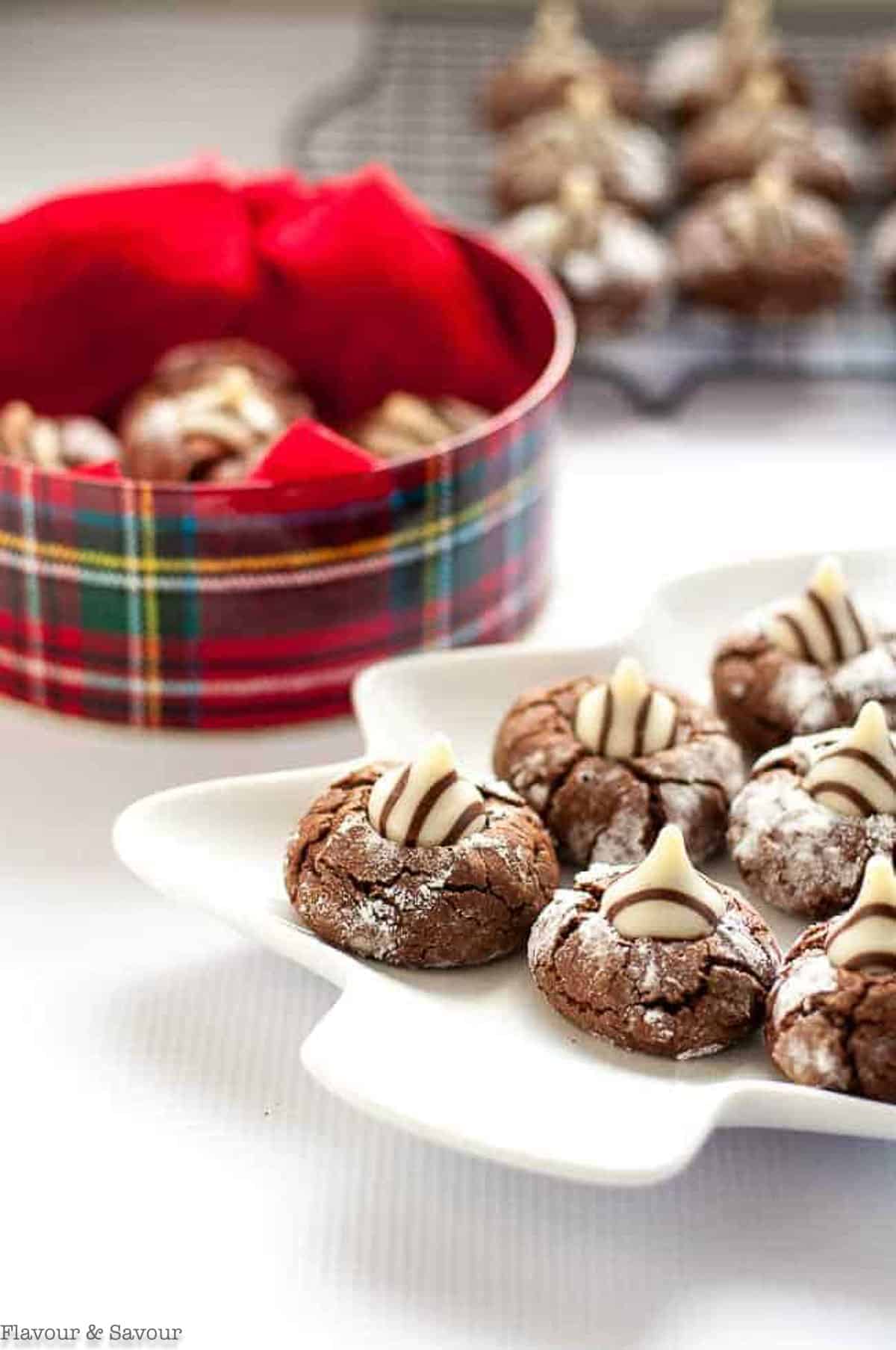 a plate of chocolate Zebra cookies near a cookie tin