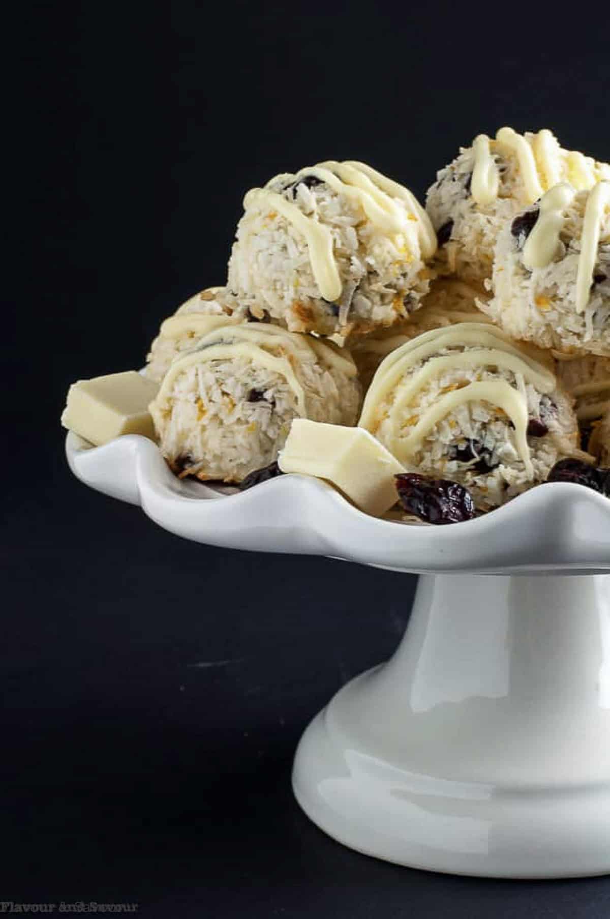 cranberry white chocolate macaroons piled on a pedestal cake plate