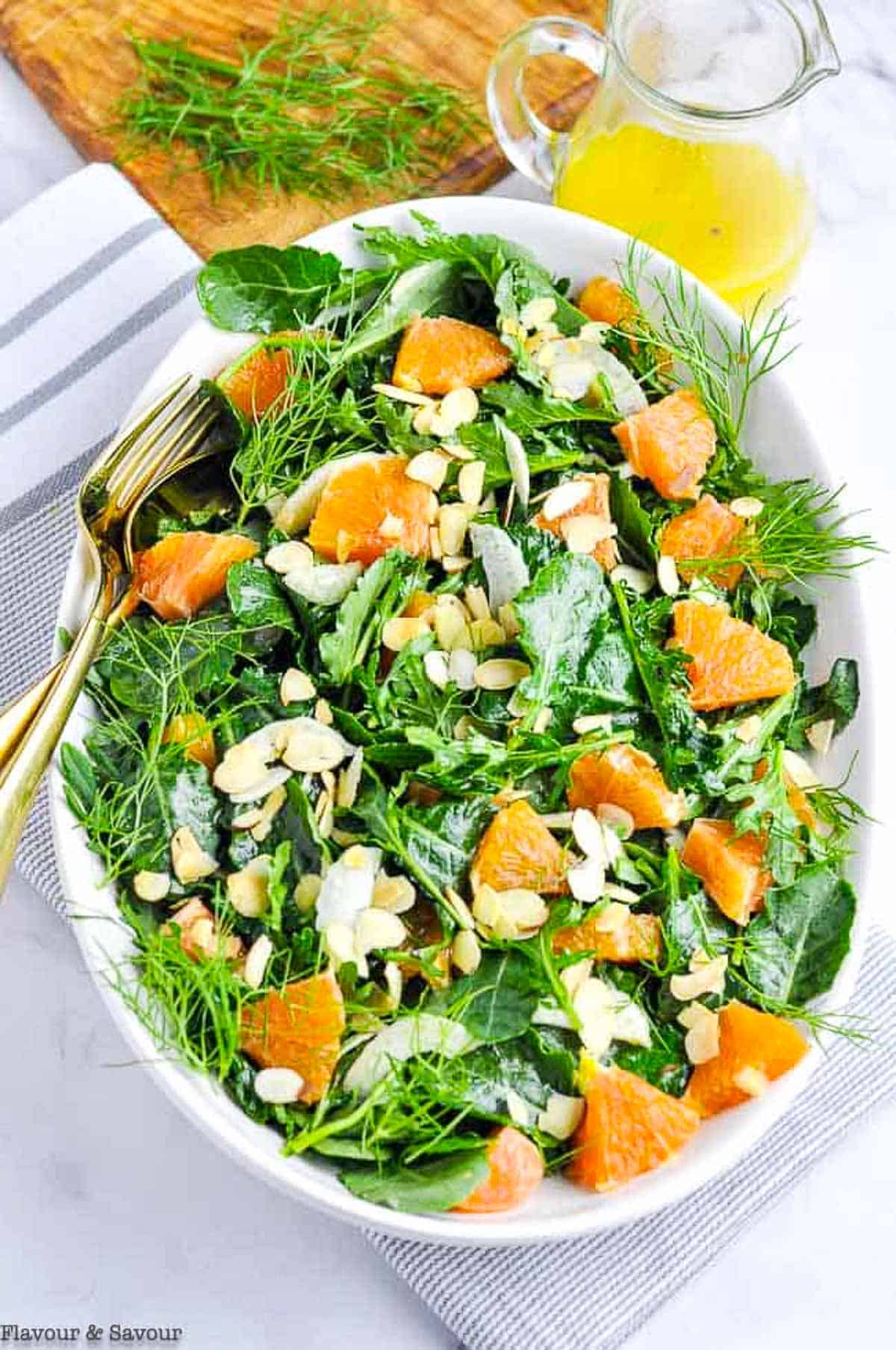 overhead view of a salad made with baby kale, cara cara oranges and toasted almonds