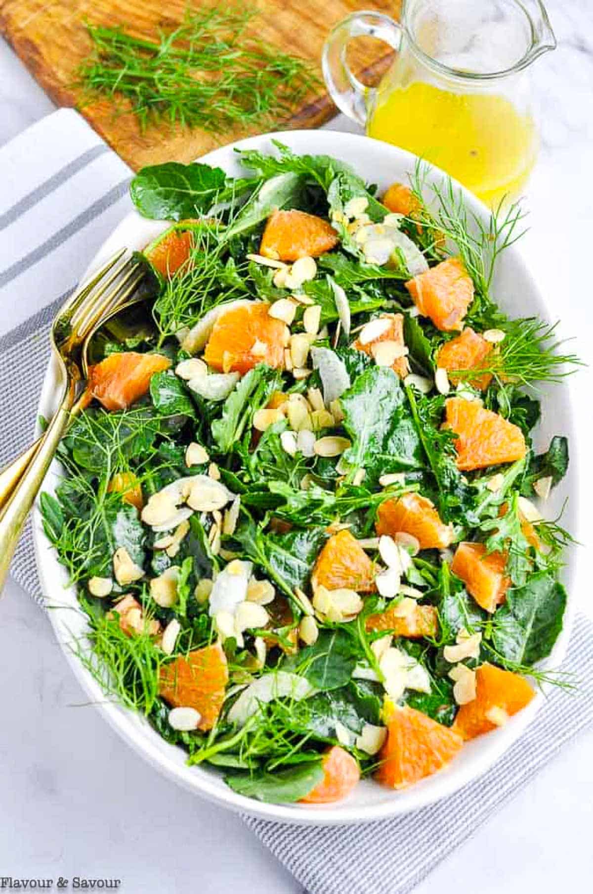 Kale and Cara Cara Orange Salad with baby kale in a shallow oval bowl.