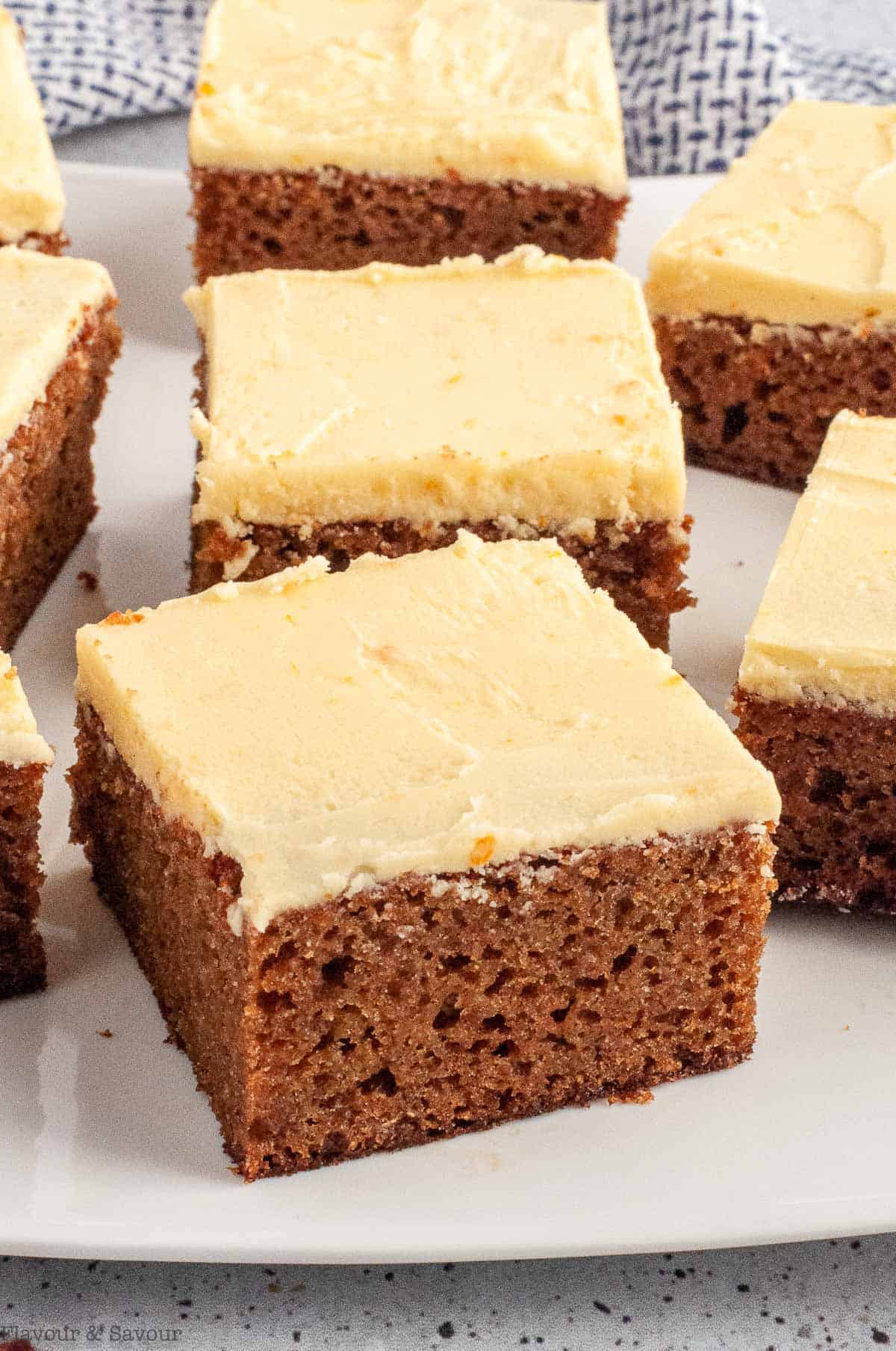 squares of orange gingerbread cake with vanilla orange frosting