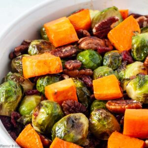 Roasted Brussels sprouts and sweet potatoes in a white bowl.