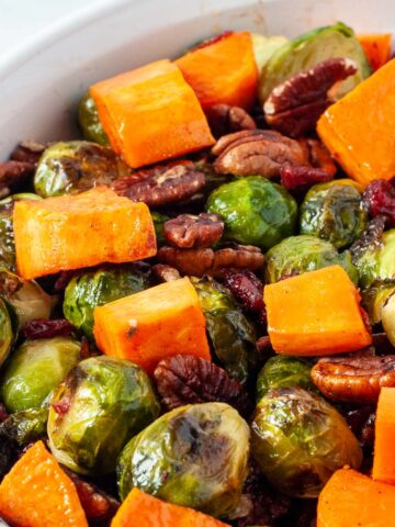 Roasted Brussels sprouts and sweet potatoes in a white bowl.