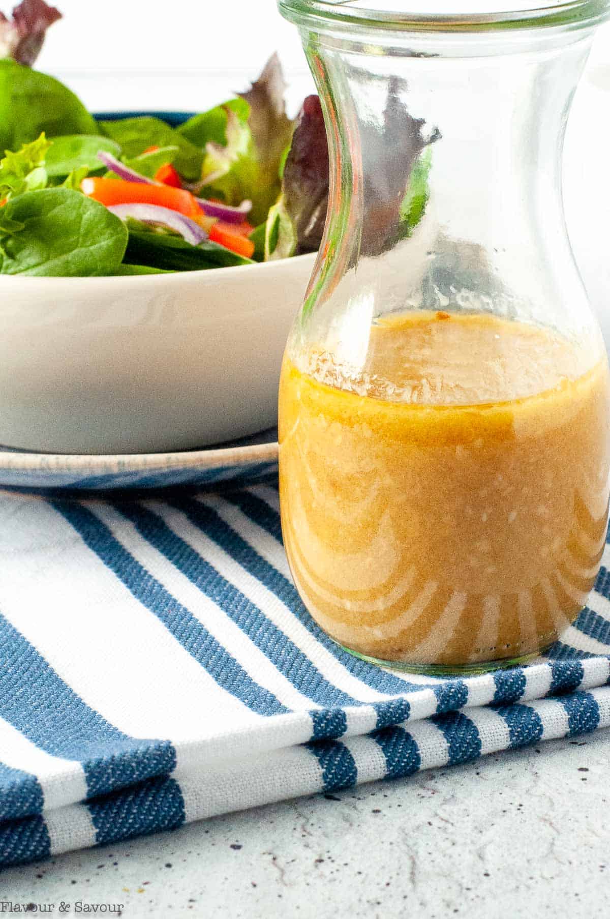 Close up view of a glass of sesame miso vinaigrette.