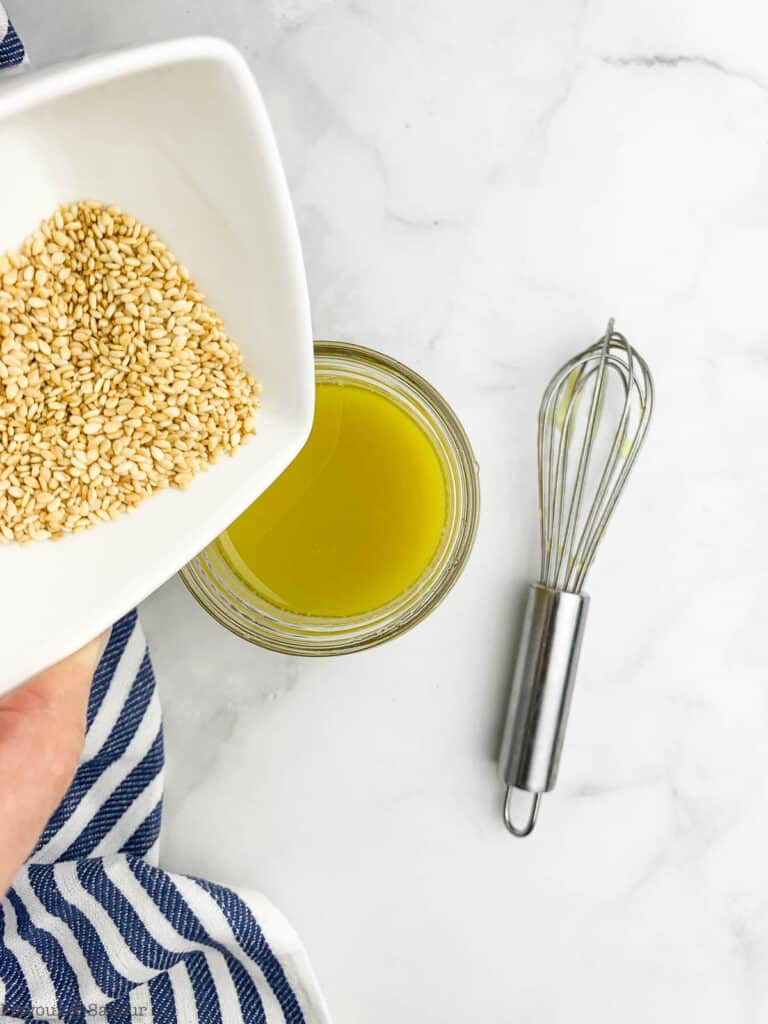 Adding sesame seeds to miso dressing.