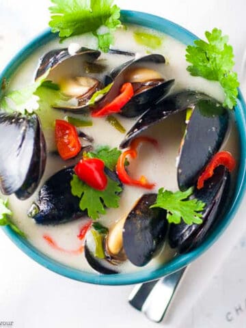 A bowl of steamed Thai mussels in coconut milk